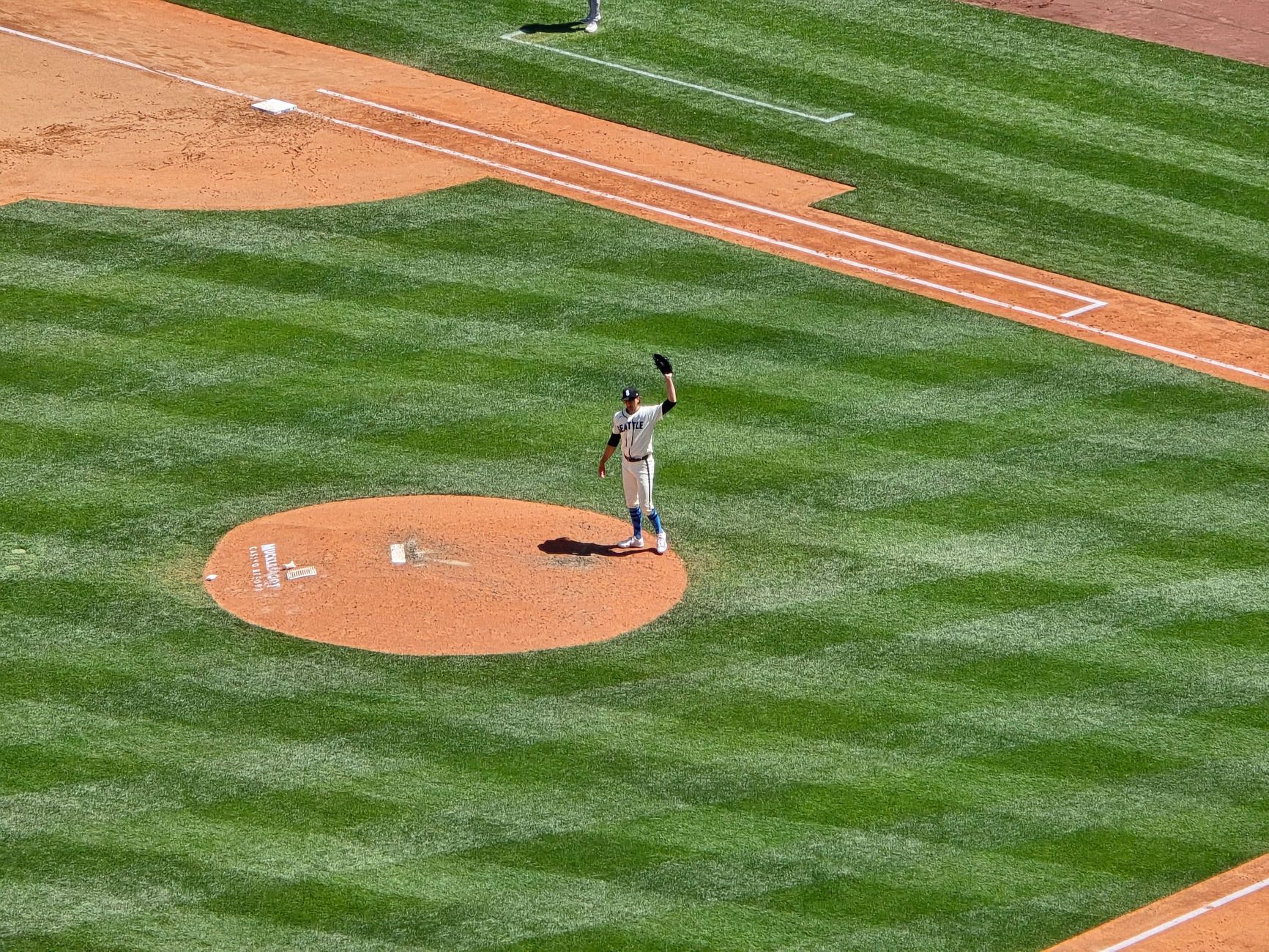 Aerial view of a baseball pitcher on the mound during a game in Seattle, WA under sunny skies.