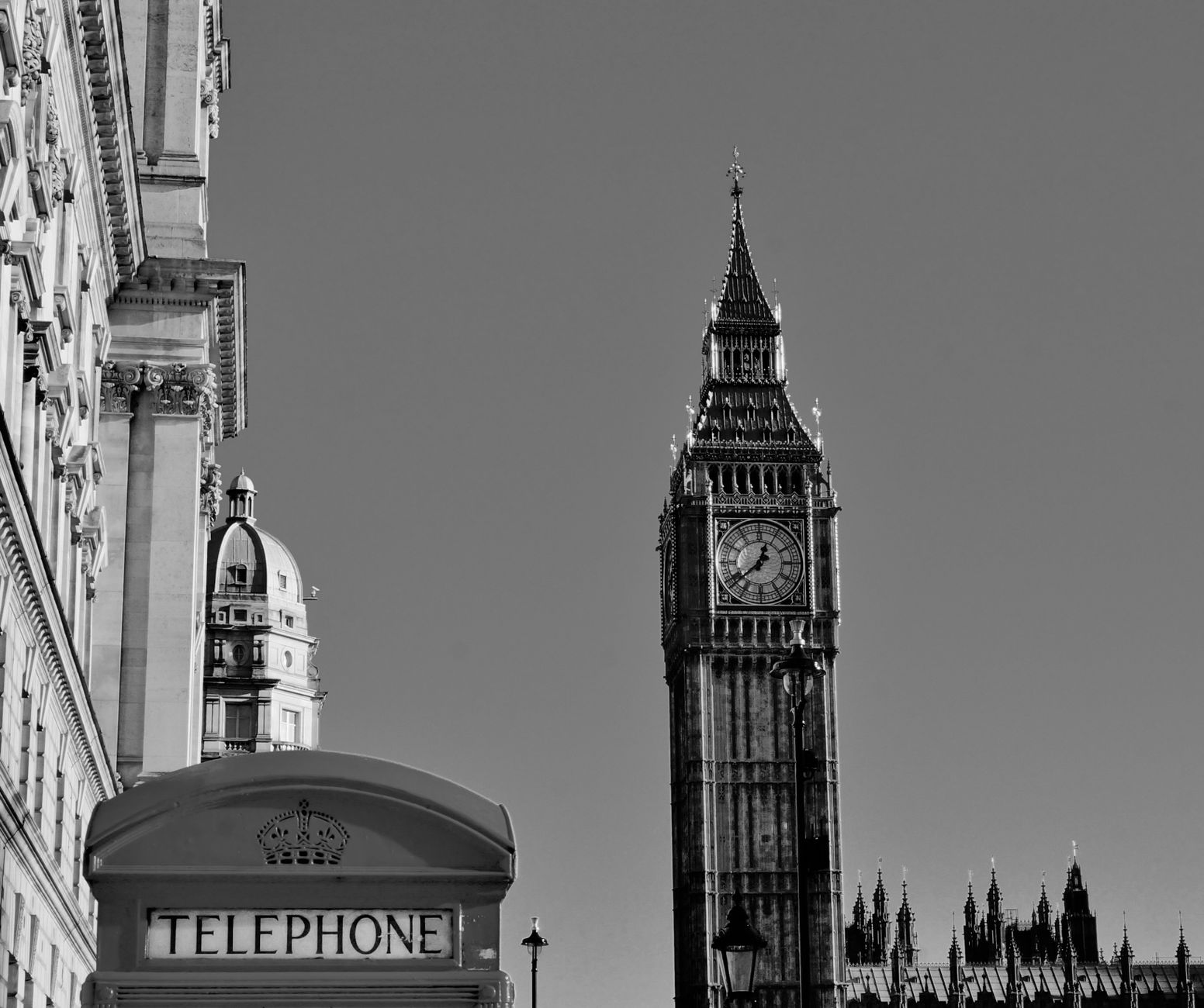 Classic view of Big Ben and a London telephone booth in black and white.